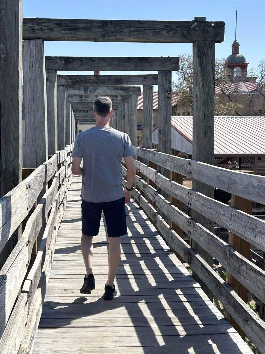 Larry walking away down the wooden catwalk above the Fort Worth Stockyards
