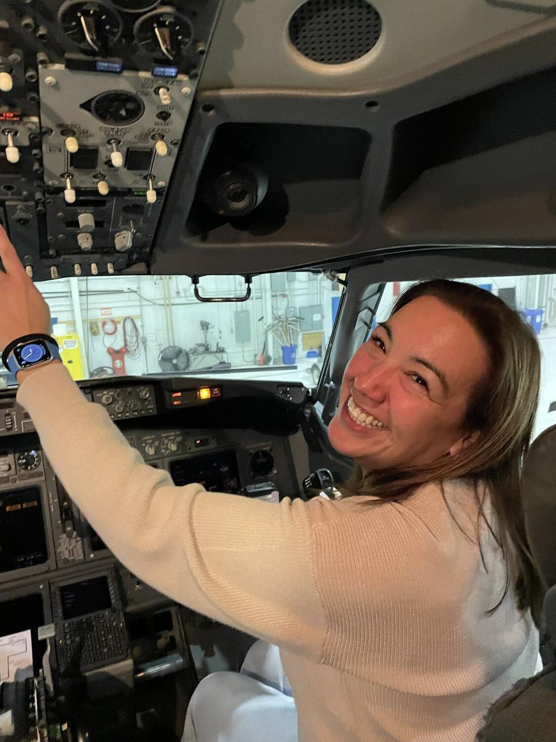 Ellice Edey at the controls in an aircraft cockpit, smiling