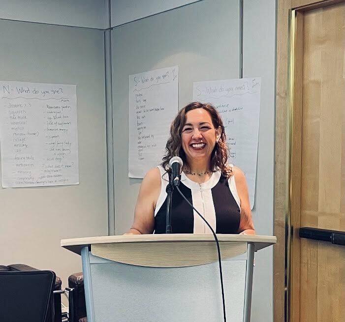 Ellice speaking at a podium